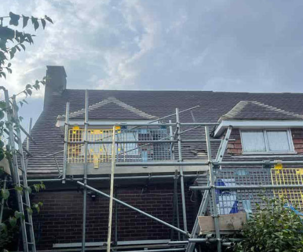 This is a photo of a roof with two dormers that is having some damaged tiles replaced. Works carried out by TVB Roofing Wellingborough